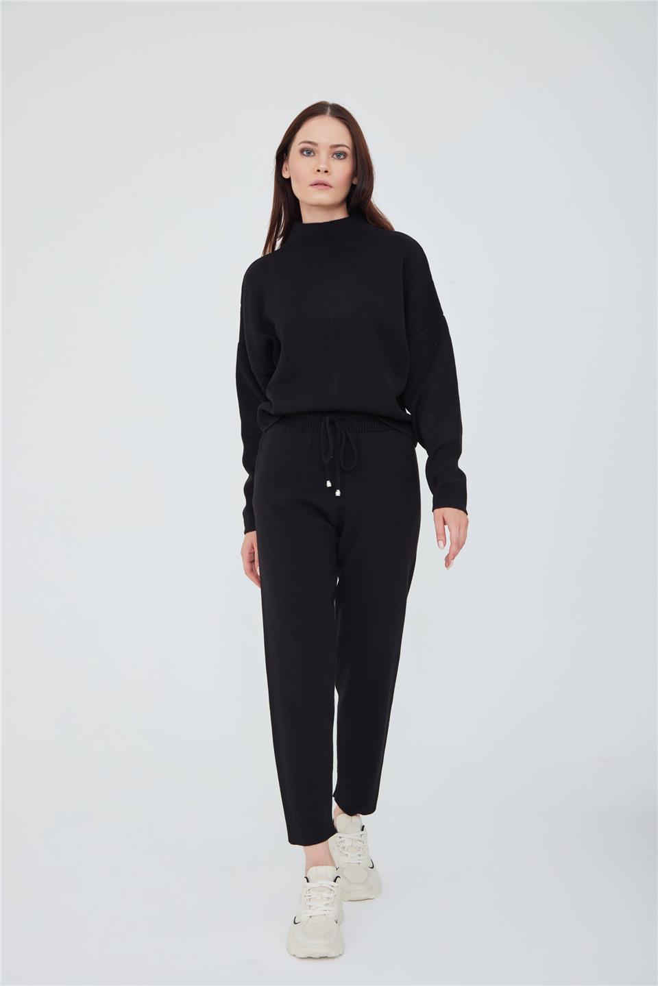 A model wears LFN10751 - Drop Shoulder Turtleneck Knıt Sweater And Slım Fıt Knıt Trousers Wıth Pockets Deep Ink Black - Siyah, wholesale Suit of Lefon to display at Lonca