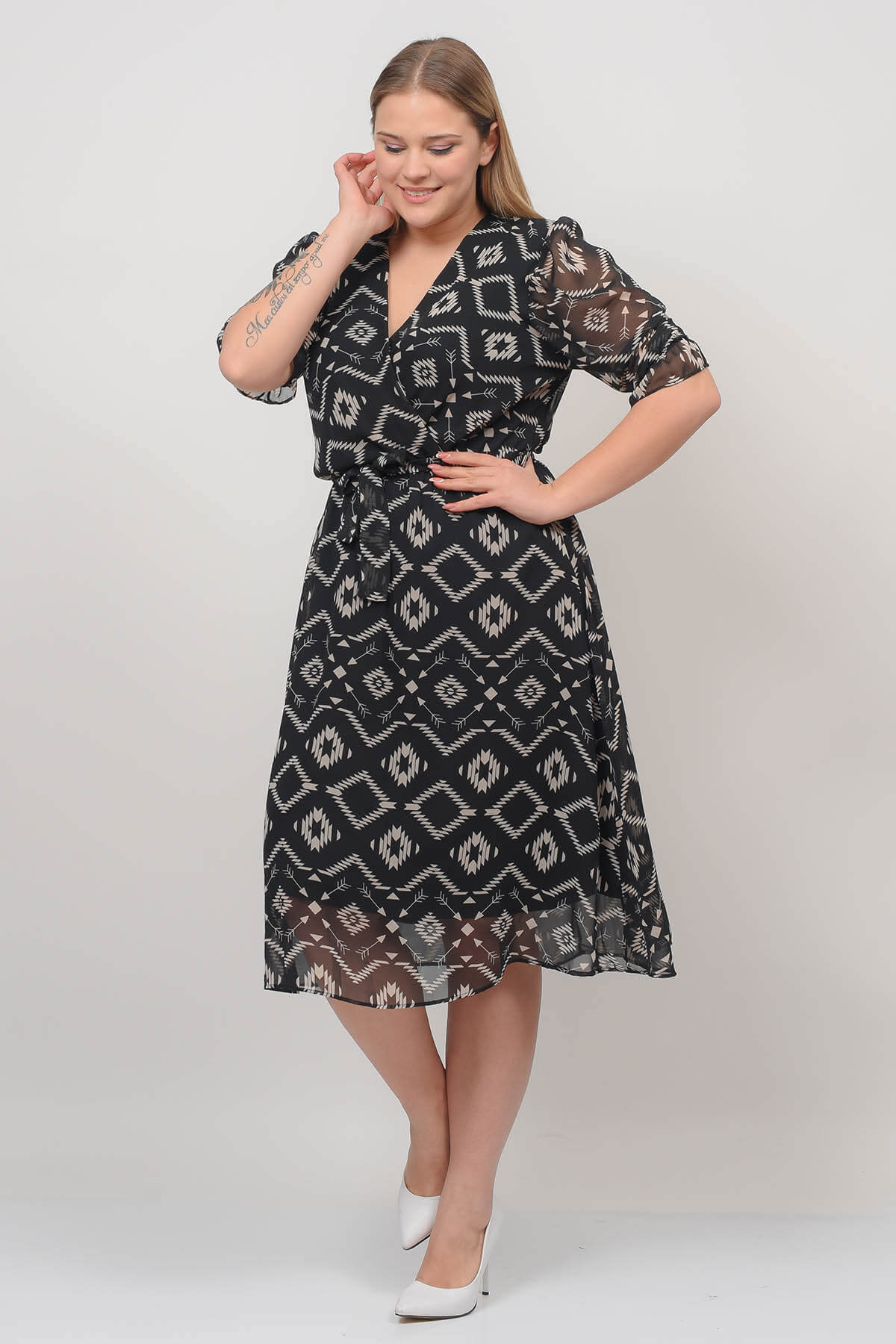 A model wears 40178 - Double Breasted Neck Midi Plus Size Patterned Chiffon Dress, wholesale Dress of Mode Roy to display at Lonca