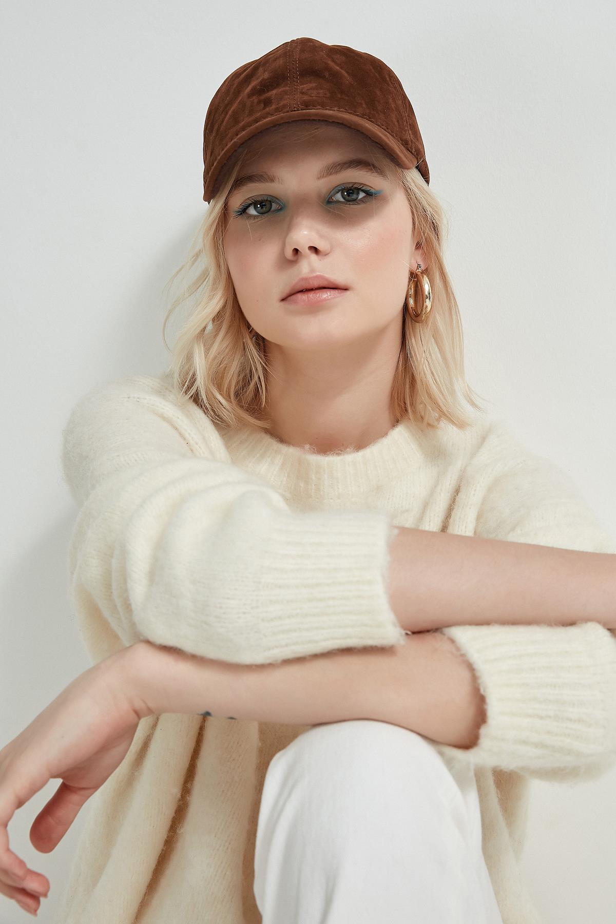 A model wears NSV11145 - Suede Cap - Brown, wholesale Hat of Nesvay to display at Lonca
