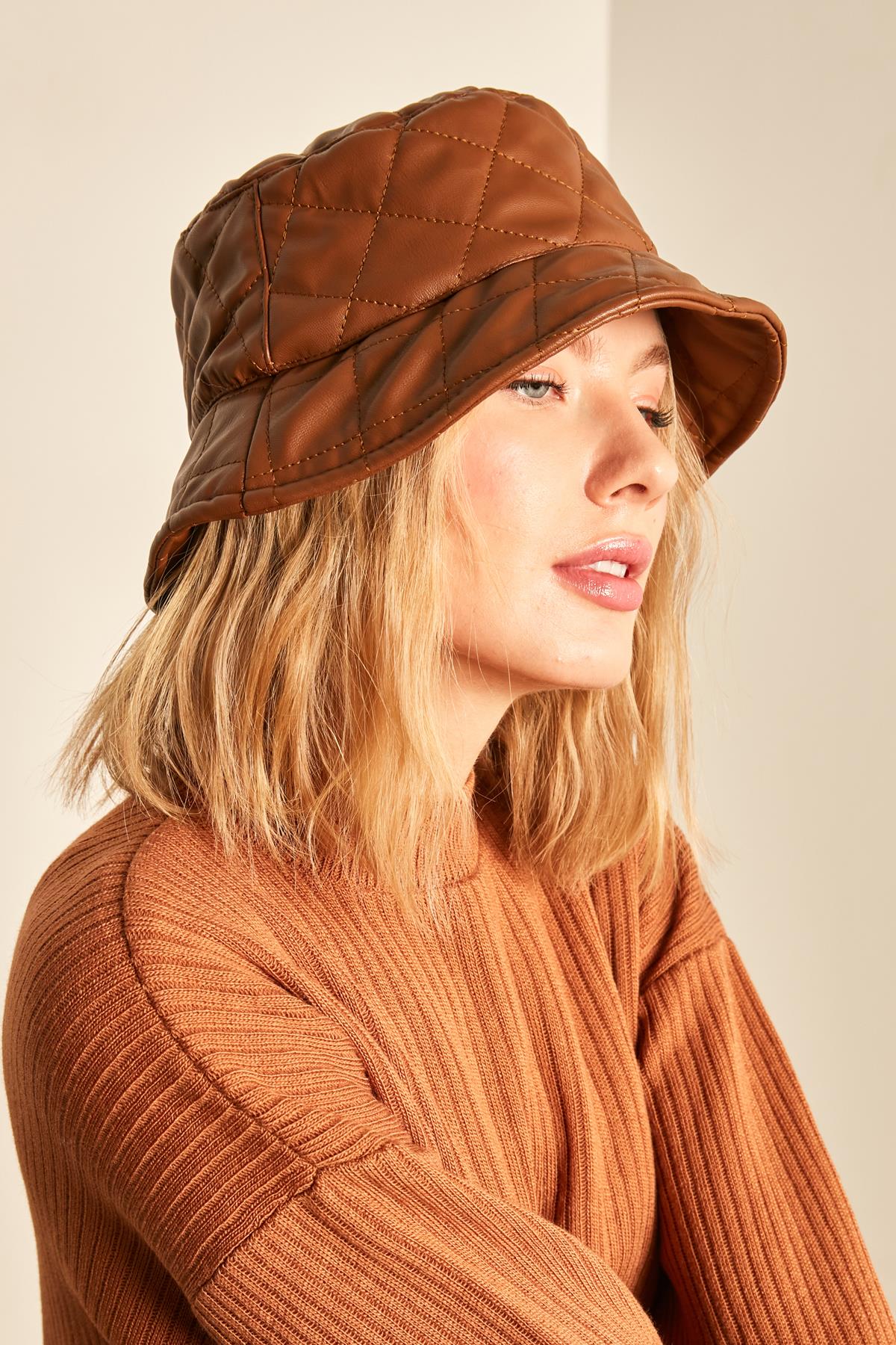A model wears NSV11178 - Quilted Bucket Hat - Tan, wholesale Hat of Nesvay to display at Lonca
